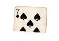 A torn half of a vintage seven of spades playing card.
