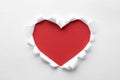 Torn heart shaped hole in white paper. Red space for text Royalty Free Stock Photo