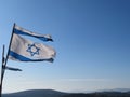 Torn Israeli flags in blue sky in Galilee mountain landscape