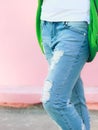 Torn jeans on a pink background on girl's legs light picture