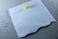 Torn lined note paper with date and theme fields pinned on gray styrofoam surface Royalty Free Stock Photo