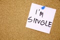 Torn note paper attached with blue pin to cork board, good as background or backdrop I am single Royalty Free Stock Photo