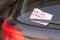 Torn note on the rear window wiper of a car with the German inscription - Do you want to sell your car - and a hidden phone number Royalty Free Stock Photo