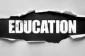 Torn paper with bold grunge word EDUCATION. Concept of learning, knowledge, teaching, training, school, university, academic Royalty Free Stock Photo