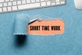 Torn paper revealing the text SHORT TIME WORK Royalty Free Stock Photo