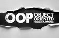 Torn paper reveals the bold acronym OOP with the words Object Oriented Programming, representing software development, coding Royalty Free Stock Photo
