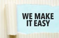 torn paper with text we make it easy and blue background Royalty Free Stock Photo