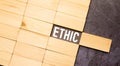 torn paper with word ethics. wooden block