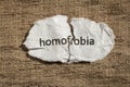 Torn paper written homofobia, portuguese and spanish word for ho