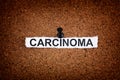 Torn piece of paper with the word Carcinoma pinned on a cork board Royalty Free Stock Photo