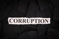 Torn pieces of black paper with the word Corruption Royalty Free Stock Photo