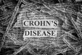 Torn pieces of paper with the words Crohn`s Disease