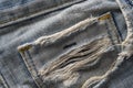 Torn pocket on old blue jeans. Blue retro jeans fabric background or denim texture. Close up Royalty Free Stock Photo