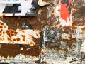 Torn poster on rust metal texture. Old grungy street wall with ripped rock concert advertisements Royalty Free Stock Photo