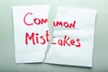 Torn sheet of paper with text COMMON MISTAKES on light background