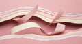 Torn strips of paper in pastel hues of pink, peach, and white create a layered, flowing pattern Royalty Free Stock Photo