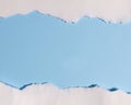 Torn white paper creating border on light blue background with empty copy space for design or text Royalty Free Stock Photo