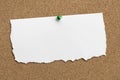 Torn White Paper With Green Tack Pin on Cork Board Royalty Free Stock Photo