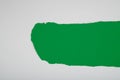 Torn white paper revealing a green background. Royalty Free Stock Photo