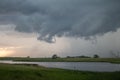 A tornado forms beneath a supercell storm with funnel cloud extending towards the ground. Royalty Free Stock Photo