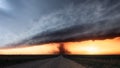 Tornado over a dirt road in Kansas at sunset