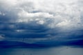 Tornado and storm clouds forming over calm sea.Boat running away from a tornado in stormy sea