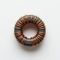 A toroidal inductor featuring a black ferrite core wrapped with copper wire coils. The Royalty Free Stock Photo