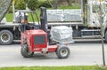 Toronto, Canada - April 28, 2020: Workman Driving a Red Forklift to Move a Pile of Concrete Patio Stones on a Suburban Street #2