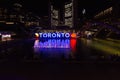 Toronto sign lit up at night, on Nathan Phillips Square is seen with Toronto City Hall in background Royalty Free Stock Photo