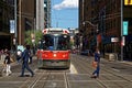 TORONTO, CANADA - 06 27 2016: City dwellers crossing the street in front of an old streetcar on King at Younge st