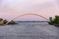 Beautiful soft pink colors at dusk with a boat sailing under the Humber Bay Arch Bridge and Lake Ontario Royalty Free Stock Photo