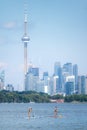 Toronto, Canada - June 28, 2020 : Women enjoying the water paddle boarding across the lake, with the Toronto skyline in the back