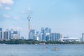 Toronto, Canada - June 28, 2020 : Women enjoying the water paddle boarding, with the Toronto skyline in the backgr