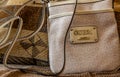 Luxury GUESS beige handbag on a brown pattern couch