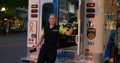 Toronto, Canada - May 6, 2023: Paramedic opens ambulance door goes outside. Young woman paramedic smiles looks at camera