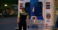 Toronto, Canada - May 6, 2023: Paramedic opens ambulance door goes outside. Young woman paramedic smiles looks at camera
