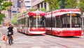 TORONTO, CANADA - 06 05 2021: New Bombardier-made TTC streetcars sharing the road with cyclists on King street in Royalty Free Stock Photo