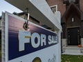 Sign for sale in front of a detached house in residential area. Royalty Free Stock Photo