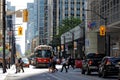 TORONTO, CANADA - 06 28 2016: Pedestrians crossing King street in front of an old streetcar in downtown Toronto in