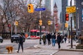 TORONTO, CANADA - 01 04 2020: Pedestrians crossing the University Avenue at Queen street with Old City Hall Clock tower