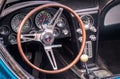 TORONTO, CANADA - 08 18 2018: Steering wheel with logo on horn button, dials and knobs on front panel of 1966 Chevrolet Corvette