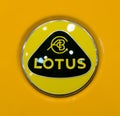 Toronto, Canada - 02 25 2023: Yellow rounded logo of Lotus Cars Limited on orange hood of Lotus sports car displayed on