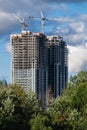 Toronto condo towers construction showing cranes and with trees in the foreground Royalty Free Stock Photo