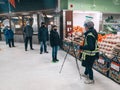 Toronto, Ontario, Canada - 19 December, 2020: Store worker measures customers temperature with a non-contact infrared thermometer