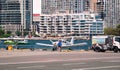 Toronto, Ontario, Canada - 08 11 2023 : A female pilot walking in front of small turboprop airplanes sitting on tarmac