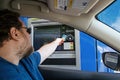 Toronto, Ontario, Canada - June 20, 2020: Caucasian bearded man taking cash money from ATM machine at drive through bank. Driver