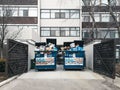 Toronto, Ontario, Canada - March 08, 2020: Litter garbage large blue bins standing outdoors by residential condo building