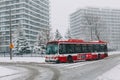 Toronto, Ontario, Canada - November 22, 2020: Toronto public transport TTC red bus during heavy winter snowstorm snowfall outdoors