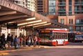 Toronto, Ontario, Canada - 10 03 2022: Passengers at Finch subway station bus terminal lined up in front of red NOVABUS bus owned Royalty Free Stock Photo