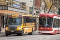 Toronto Streetcar passing next to a Yellow American School bus, Downtown Toronto, Ontario. Royalty Free Stock Photo